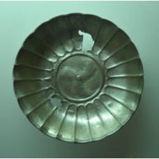 A three-pointed cross in the center of a silver bowl
